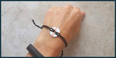 A bracelet made from a washer painted to look like a baseball