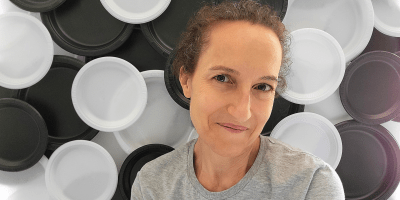 Woman posing in front of backdrop made from black and white paper plates
