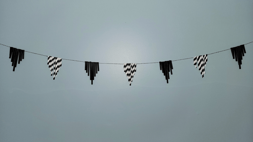 Black and White garland made from paper straws, hanging on wall