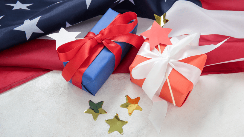 Red and blue wrapped gift packages, with an American flag i the background