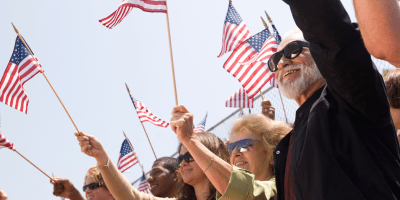 American flag flying above citizens participating in community life.
